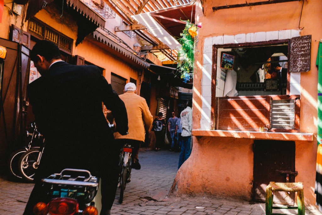 Motorcyclists riding through a Marrakech souk